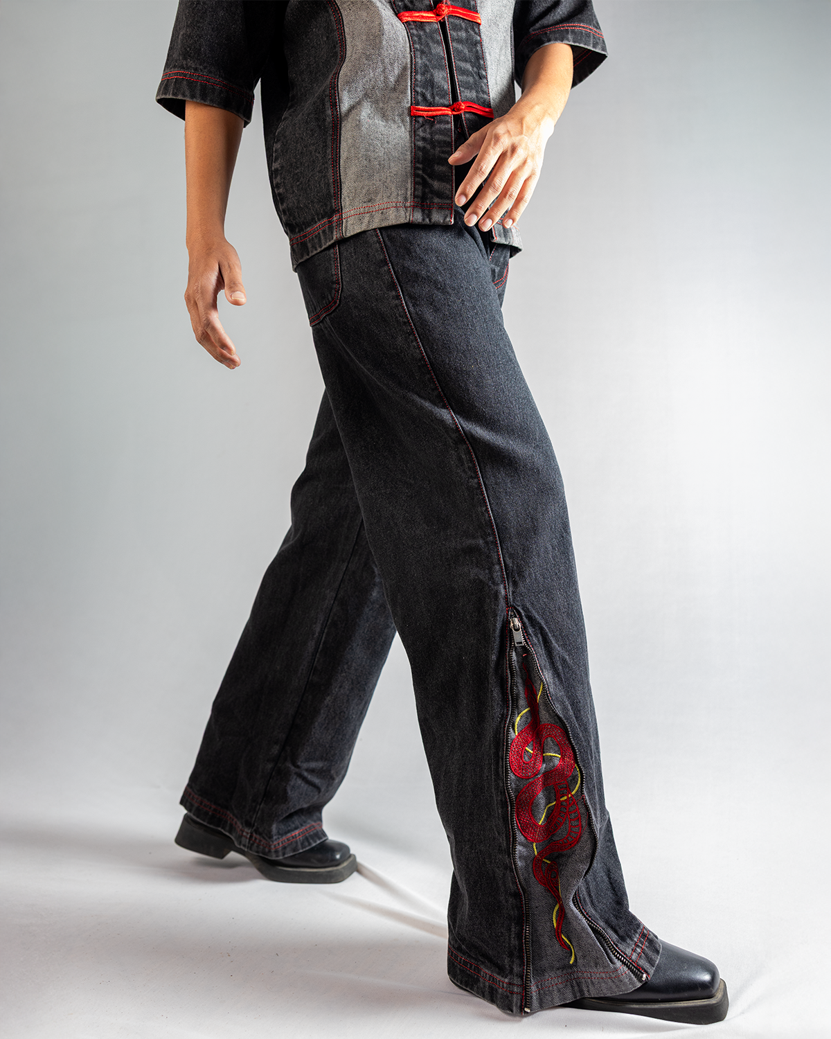 A model wearing Black Year of Snake jeans, featuring stylish design and detailed snake embroidery on the side.