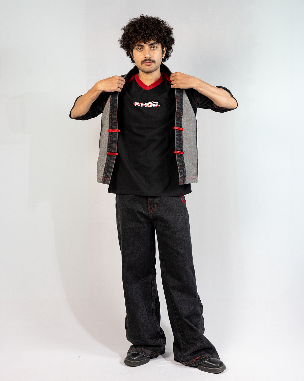 Model wearing Black Year of Snake jeans with a stylish outfit, showcasing transformation and strength in fashion.