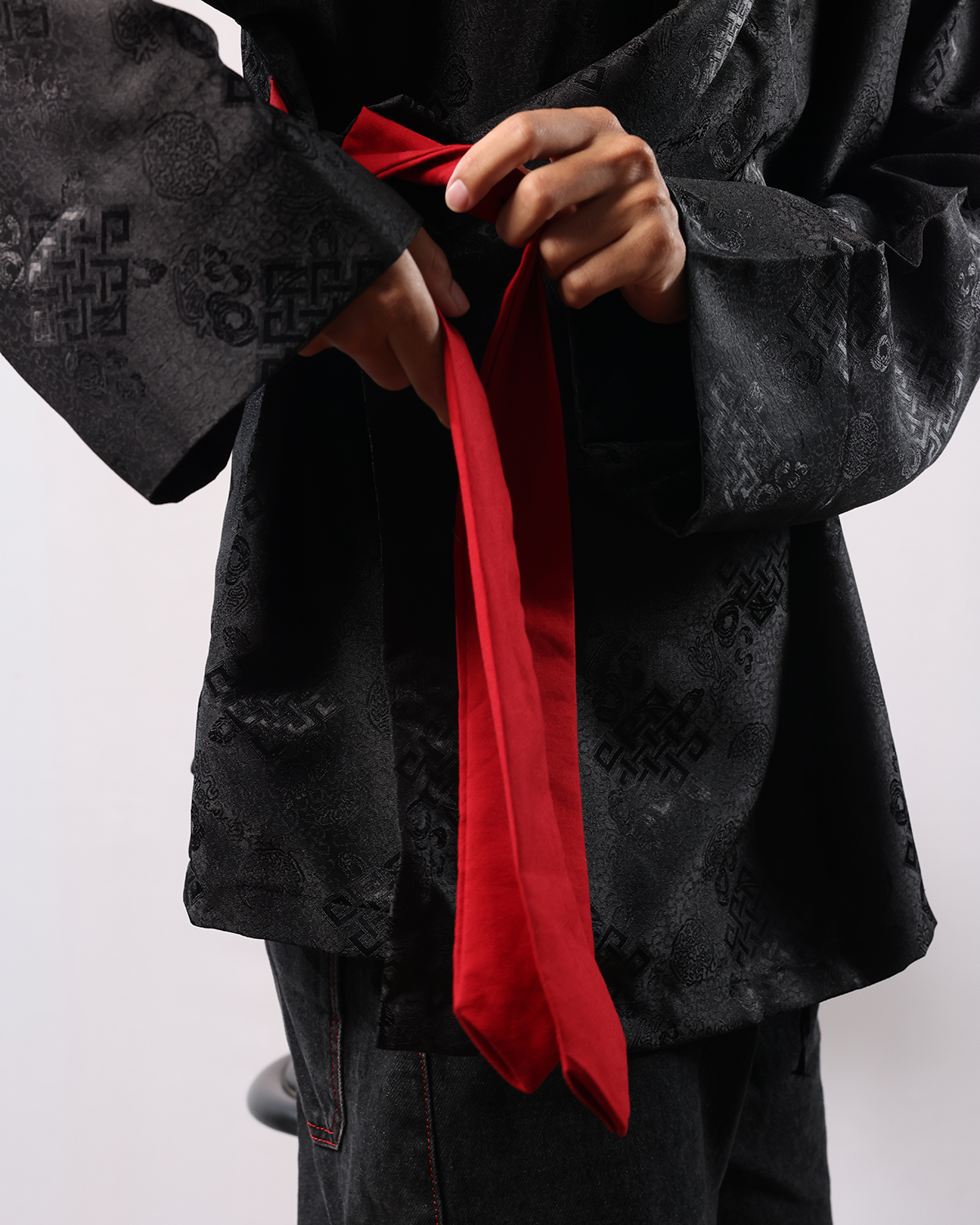 Wonju kimono shirt with red tie detail and black patterned fabric.