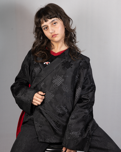 Wonju kimono shirt in black, featuring intricate designs, modeled by a young woman with wavy hair.
