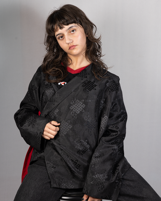 Wonju kimono shirt in black, featuring intricate designs, modeled by a young woman with wavy hair.